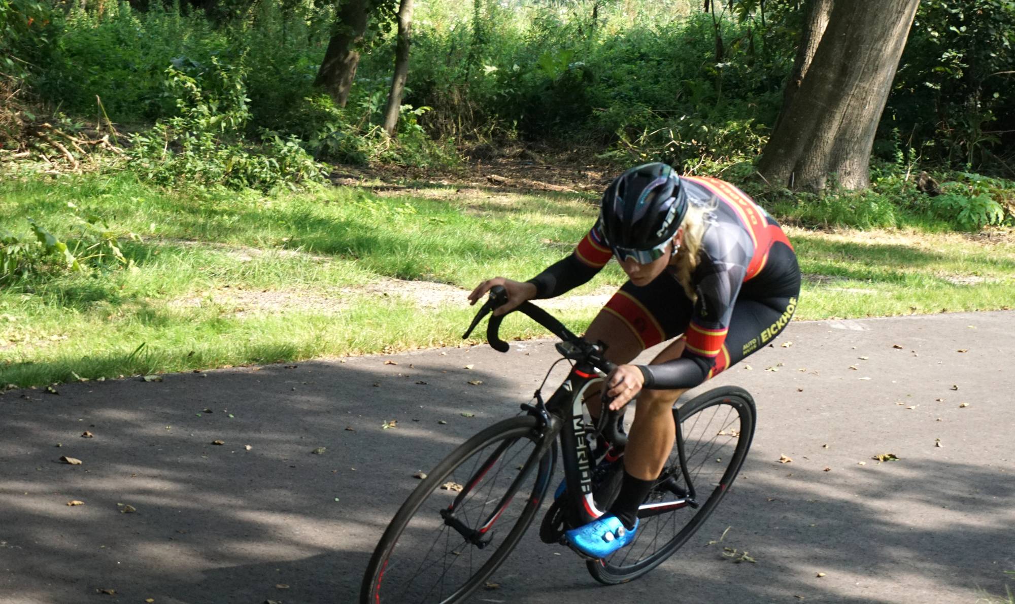 Foto van Cycle Capital TEAM NH rensters Michelle de Graaf in een bocht aan de Noord-Oostzijde van het wielerparcours op sportpark de Weeren in Amsterdam Noord.