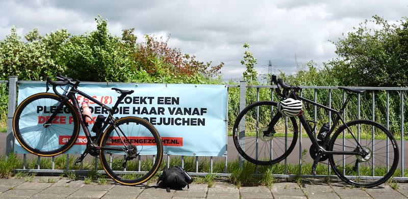 Foto van 2 geparkeerde racefietsen op het wielerparcours in Amsterdam Noord